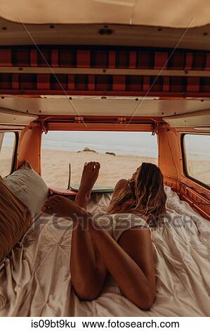 Young female surfer looking out from back of recreational vehicle at beach, Jalama, California, USA View Large Photo Image Stock Photograph - Young female surfer looking out from back of recreational vehicle at beach, Jalama, California, USA. Fotosearch
