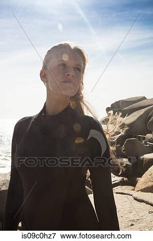 Young female surfer looking sideways on beach, Cape Town, Western Cape, South Africa View Large Photo Image Stock Photo - Young female surfer looking sideways on beach, Cape Town, Western Cape, South Africa. Fotosearch
