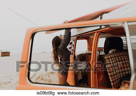 Young female surfer removing surfboard from recreational vehicle roof at beach, Jalama, California, USA View Large Photo Image Stock Image - Young female surfer removing surfboard from recreational vehicle roof at beach, Jalama, California, USA. Fotosearch