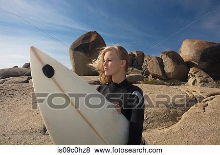 Young female surfer with flyaway hair looking out from beach rock, Cape Town, Western Cape, South Africa View Large Photo Image Stock Photo - Young female surfer with flyaway hair looking out from beach rock, Cape Town, Western Cape, South Africa. Fotosearch