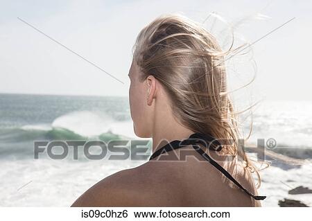 Young female surfer with flyaway long blond hair looking out at ocean waves, rear view, Cape Town, Western Cape, South Africa View Large Photo Image Stock Photograph - Young female surfer with flyaway long blond hair looking out at ocean waves, rear view, Cape Town, Western Cape, South Africa. Fotosearch
