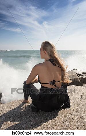 Young female surfer with long blond hair sitting on beach rock, rear view, Cape Town, Western Cape, South Africa View Large Photo Image Picture - Young female surfer with long blond hair sitting on beach rock, rear view, Cape Town, Western Cape, South Africa. Fotosearch