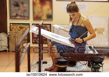 Young female tourist practicing Batik in art classroom, a traditional form of Indonesian painting View Large Photo Image Picture - Young female tourist practicing Batik in art classroom, a traditional form of Indonesian painting. Fotosearch