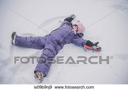 Stock Photo - Young girl making snow angel in snow. Fotosearch