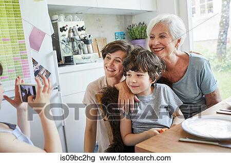 Young girl photographing, brother, mother and grandmother, using smartphone View Large Photo Image Stock Image - Young girl photographing, brother, mother and grandmother, using smartphone. Fotosearch