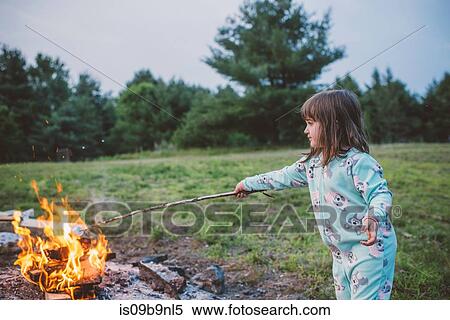 Young girl toasting marshmallow in fire View Large Photo Image Stock Photography - Young girl toasting marshmallow in fire. Fotosearch