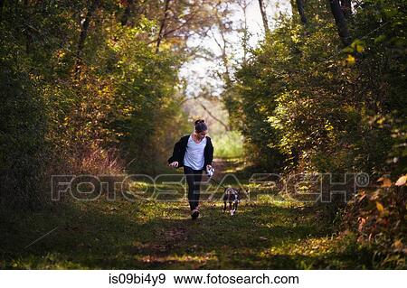Stock Photo - Young girl walking dog in rural setting. Fotosearch