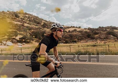 Young male cyclist cycling on rural road, side view, Exeter, California, USA View Large Photo Image Stock Image - Young male cyclist cycling on rural road, side view, Exeter, California, USA. Fotosearch