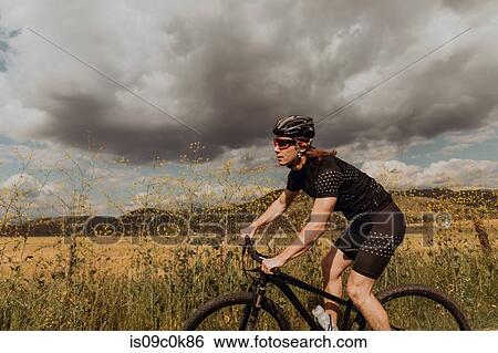 Young male cyclist cycling on rural road, side view, Exeter, California, USA View Large Photo Image Stock Photograph - Young male cyclist cycling on rural road, side view, Exeter, California, USA. Fotosearch