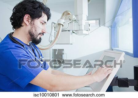 Young male radiographer operating X-ray machine control panel in radiology department View Large Photo Image Stock Image - Young male radiographer operating X-ray machine control panel in radiology department. Fotosearch