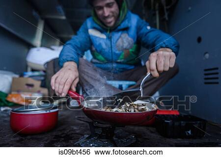 Young male rock climber cooking breakfast in camper van View Large Photo Image Stock Photograph - Young male rock climber cooking breakfast in camper van. Fotosearch