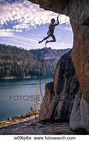 Young male rock climber dangling on rope from rock face, High Sierras, California, USA View Large Photo Image Stock Image - Young male rock climber dangling on rope from rock face, High Sierras, California, USA. Fotosearch