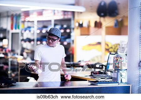 Young male sales assistant looking at socks at skateboard shop counter View Large Photo Image Stock Image - Young male sales assistant looking at socks at skateboard shop counter. Fotosearch