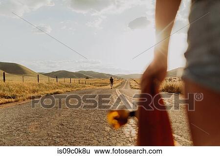 Young male skateboarder skateboarding on rural road, girlfriend watching, Exeter, California, USA View Large Photo Image Stock Photograph - Young male skateboarder skateboarding on rural road, girlfriend watching, Exeter, California, USA. Fotosearch