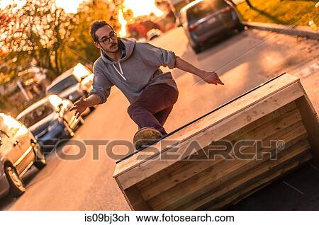 Young male skateboarder turning moving up ramp on suburban street at sunset View Large Photo Image Stock Image - Young male skateboarder turning moving up ramp on suburban street at sunset. Fotosearch
