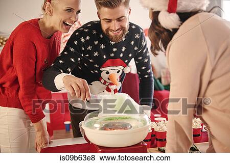Stock Photo - Young man and women preparing candyfloss at christmas party. Fotosearch