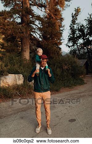 Young man carrying female toddler on shoulders on rural valley road, portrait, Mineral King, California, USA View Large Photo Image Stock Image - Young man carrying female toddler on shoulders on rural valley road, portrait, Mineral King, California, USA. Fotosearch