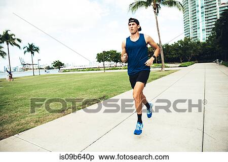 Young man exercising outdoors, running, South Point Park, Miami Beach, Florida, USA View Large Photo Image Stock Photography - Young man exercising outdoors, running, South Point Park, Miami Beach, Florida, USA. Fotosearch