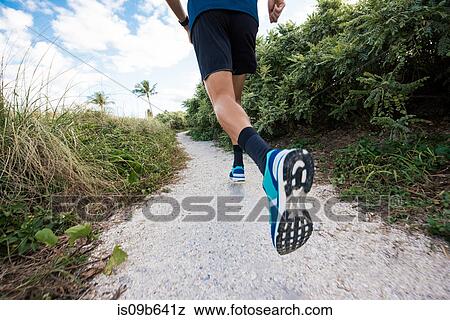 Stock Photo - Young man exercising, running outdoors, rear view, low section, South Point Park, Miami Beach, Florida, USA. Fotosearch