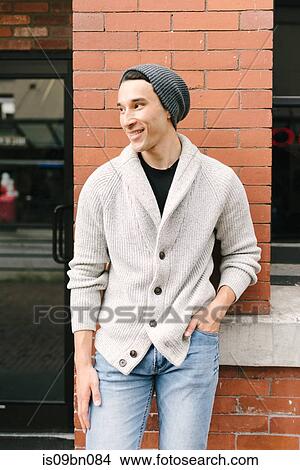 Young man leaning against brick wall, Vancouver, Canada View Large Photo Image Picture - Young man leaning against brick wall, Vancouver, Canada. Fotosearch
