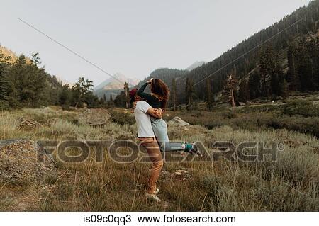 Stock Image - Young man lifting up his girlfriend in rural valley, Mineral King, California, USA. Fotosearch
