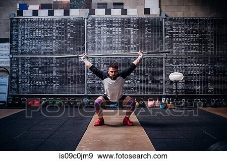 Young man lifting weight bar in gym View Large Photo Image Stock Photo - Young man lifting weight bar in gym. Fotosearch