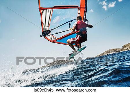 Young man mid air windsurfing ocean waves, side view, Limnos, Khios, Greece View Large Photo Image Stock Photography - Young man mid air windsurfing ocean waves, side view, Limnos, Khios, Greece. Fotosearch