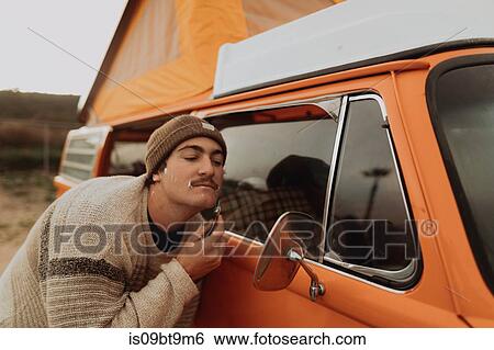Young man shaving by recreational vehicle wing mirror, Jalama, California, USA View Large Photo Image Stock Photograph - Young man shaving by recreational vehicle wing mirror, Jalama, California, USA. Fotosearch