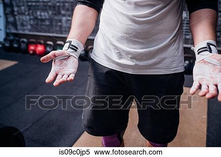Young man showing powdered palms in gym View Large Photo Image Stock Photography - Young man showing powdered palms in gym. Fotosearch