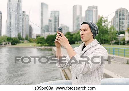 Young man taking photo on seawall, Yaletown, Vancouver, Canada View Large Photo Image Stock Image - Young man taking photo on seawall, Yaletown, Vancouver, Canada. Fotosearch