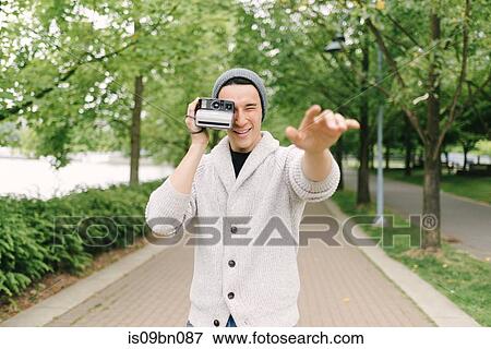 Young man taking photo with instant camera, Vancouver, Canada View Large Photo Image Stock Photo - Young man taking photo with instant camera, Vancouver, Canada. Fotosearch