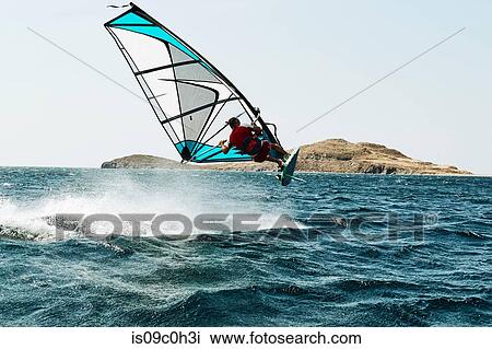 Young man windsurfing above ocean wave, rear view, Limnos, Khios, Greece View Large Photo Image Stock Image - Young man windsurfing above ocean wave, rear view, Limnos, Khios, Greece. Fotosearch