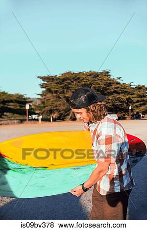 Young man with surfboard on beach, Morro Bay, California, United States View Large Photo Image Stock Photo - Young man with surfboard on beach, Morro Bay, California, United States. Fotosearch