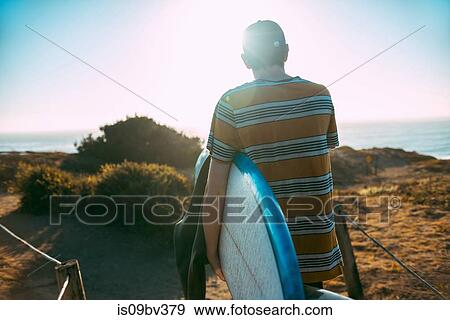 Young man with surfboard on beach, Morro Bay, California, United States View Large Photo Image Stock Photo - Young man with surfboard on beach, Morro Bay, California, United States. Fotosearch
