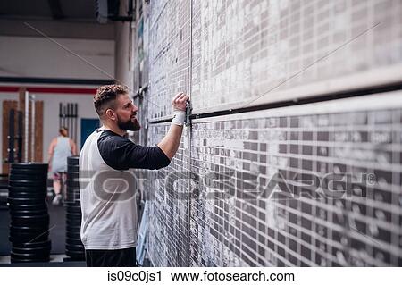 Young man writing on scoreboard in gym View Large Photo Image Stock Image - Young man writing on scoreboard in gym. Fotosearch
