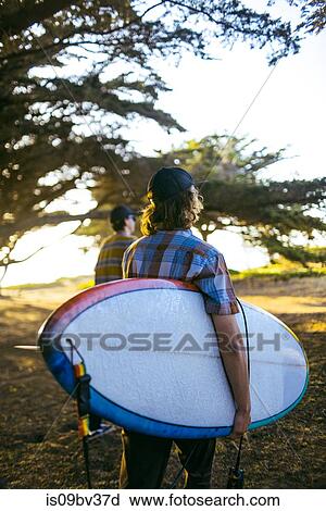 Young men with surfboard on beach, Morro Bay, California, United States View Large Photo Image Stock Image - Young men with surfboard on beach, Morro Bay, California, United States. Fotosearch