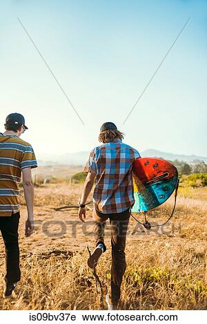 Young men with surfboard on beach, Morro Bay, California, United States View Large Photo Image Stock Image - Young men with surfboard on beach, Morro Bay, California, United States. Fotosearch