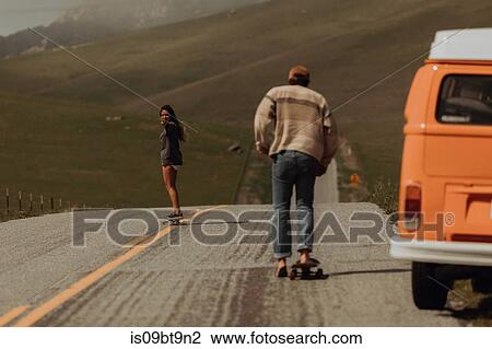 Young skateboarder couple skateboarding on rural road next to recreational vehicle, Jalama, California, USA View Large Photo Image Stock Image - Young skateboarder couple skateboarding on rural road next to recreational vehicle, Jalama, California, USA. Fotosearch