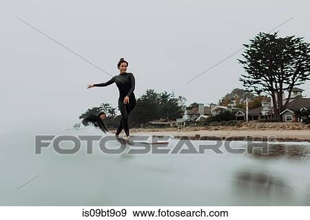 Young surfer couple surfing on misty sea, Ventura, California, USA View Large Photo Image Stock Photo - Young surfer couple surfing on misty sea, Ventura, California, USA. Fotosearch