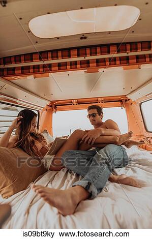 Young surfing couple reclining in back of recreational vehicle at beach, Jalama, California, USA View Large Photo Image Stock Photo - Young surfing couple reclining in back of recreational vehicle at beach, Jalama, California, USA. Fotosearch