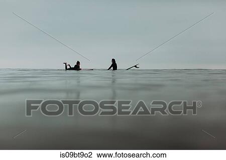 Young surfing couple with surfboards on calm misty sea, Ventura, California, USA View Large Photo Image Stock Image - Young surfing couple with surfboards on calm misty sea, Ventura, California, USA. Fotosearch