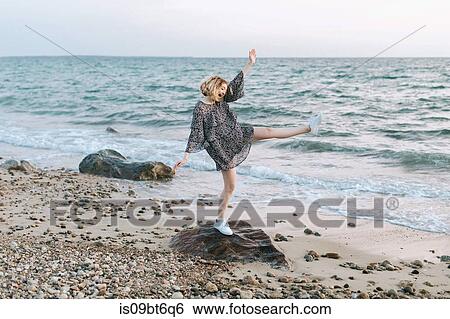 Young woman balancing on beach rock, Menemsha, Martha's Vineyard, Massachusetts, USA View Large Photo Image Stock Photograph - Young woman balancing on beach rock, Menemsha, Martha's Vineyard, Massachusetts, USA. Fotosearch