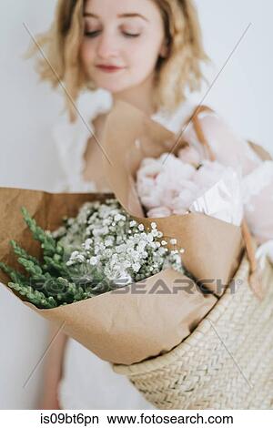 Young woman carrying straw basket with bunches of flowers View Large Photo Image Picture - Young woman carrying straw basket with bunches of flowers. Fotosearch