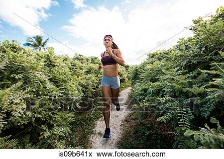 Stock Photo - Young woman exercising outdoors, running, South Point Park, Miami Beach, Florida, USA. Fotosearch
