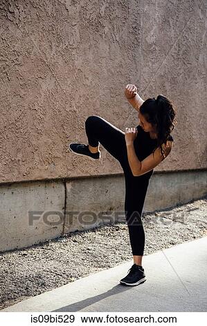 Stock Photo - Young woman exercising outdoors. Fotosearch