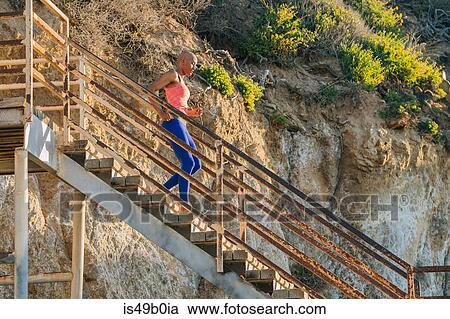 Young woman exercising, running down steps near beach, low angle view View Large Photo Image Stock Image - Young woman exercising, running down steps near beach, low angle view. Fotosearch