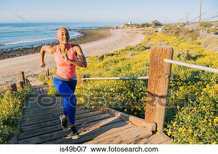 Young woman exercising, running up steps near beach, elevated view View Large Photo Image Stock Photo - Young woman exercising, running up steps near beach, elevated view. Fotosearch