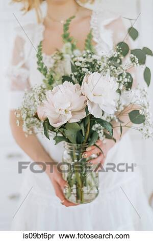 Young woman holding jar of flowers, mid section View Large Photo Image Stock Photography - Young woman holding jar of flowers, mid section. Fotosearch