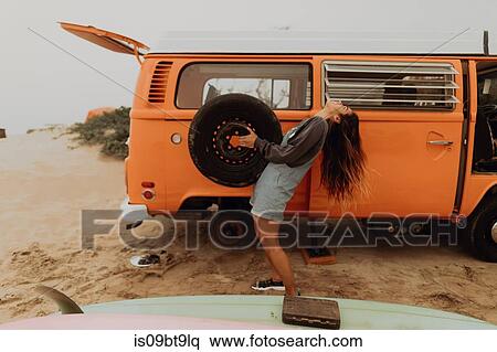 Young woman holding up recreational vehicle tyre at beach, Jalama, California, USA View Large Photo Image Stock Photography - Young woman holding up recreational vehicle tyre at beach, Jalama, California, USA. Fotosearch