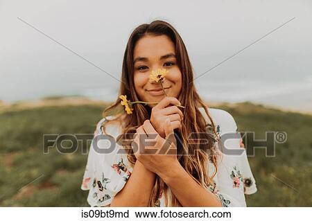Young woman holding wildflowers in front of face at coast, portrait, Jalama, California, USA View Large Photo Image Stock Image - Young woman holding wildflowers in front of face at coast, portrait, Jalama, California, USA. Fotosearch